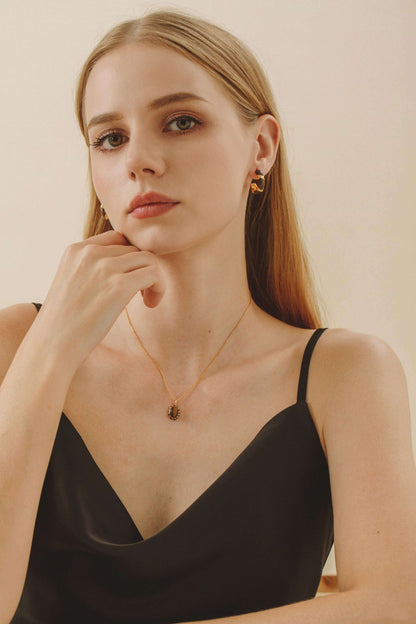 Woman wearing SUIHE Jewelry Mocha Necklace with tiger eye stone and gold vermeil chain, exuding elegance and sophistication.