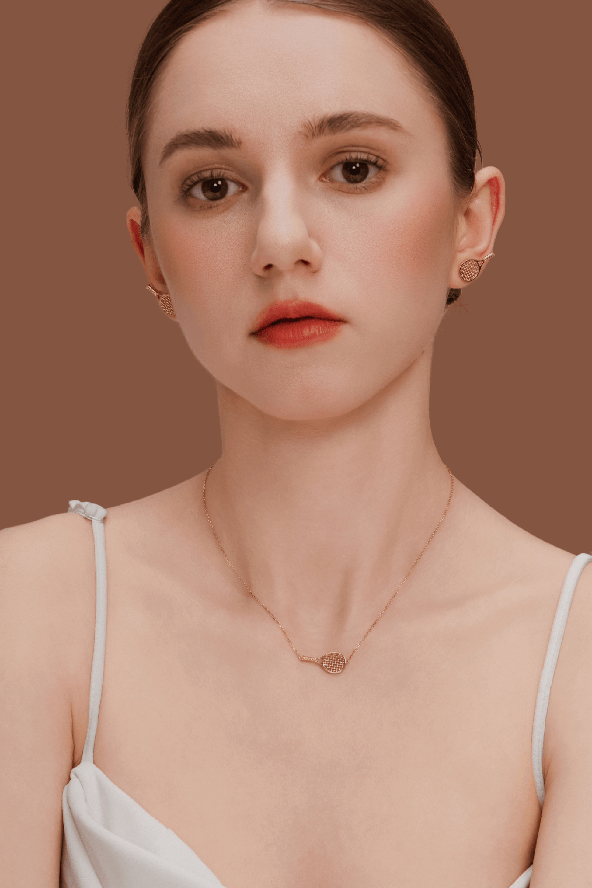Woman wearing SUIHE Jewelry's Tennis Necklace with gold-plated tennis racket pendant, showcasing sporty chic elegance.