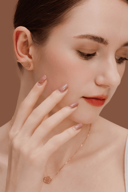Woman wearing SUIHE Jewelry gold-plated tennis racket earrings and necklace on a neutral background.