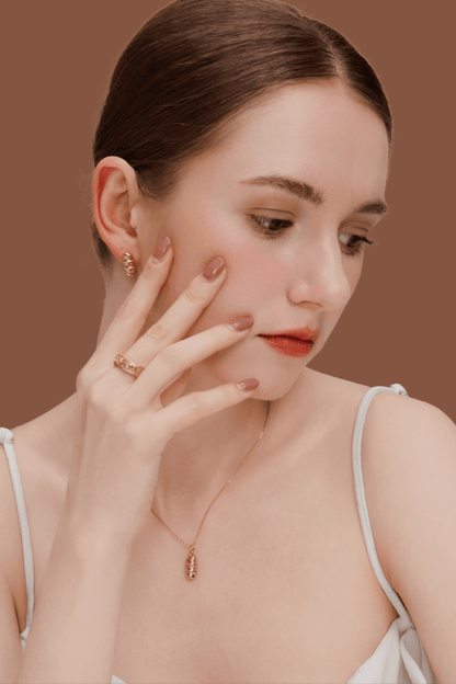 Woman wearing gold jewelry set including earrings, necklace, and hammered gold-plated Bread Platter Ring with 3D charms.