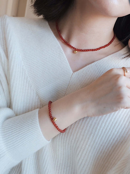 Woman wearing SUIHE Jewelry "Lucky" Red Agate Gemstone Necklace, symbolizing hope and positivity, paired with matching bracelet in 18k Gold Vermeil.