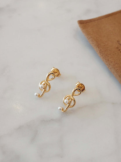 Gold "Aria" stud earrings on marble surface, featuring 18k gold vermeil over sterling silver and pearl accents by SUIHE Jewelry.