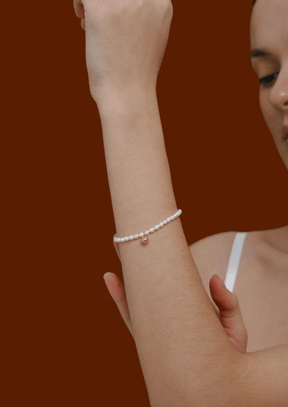 Celestia Freshwater Pearl Bracelet by SUIHE Jewelry on wrist, featuring gold-tone bead charm and adjustable clasp for elegant style.