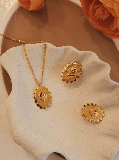 Gold vermeil tulip necklace and earrings set on a decorative plate, featuring intricate tulip designs by SUIHE Jewelry.