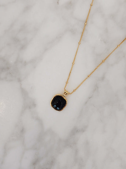 SUIHE Jewelry Nocturne Black Onyx Square Necklace on marble surface, 18k gold vermeil, symbol of strength and clarity.