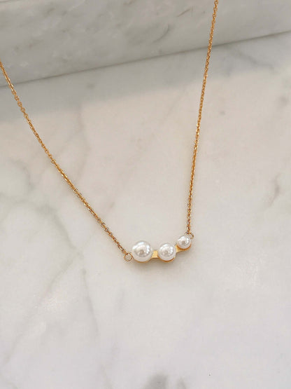 "Flare freshwater pearl necklace set on marble, featuring luminous pearls and 18k gold vermeil chain by SUIHE Jewelry."