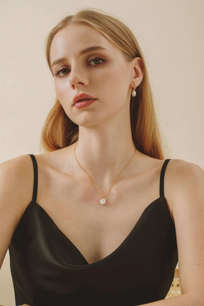 Woman wearing SUIHE Jewelry "Luna" Mother-of-pearl Necklace with black dress, showcasing elegant pendant and modern style.