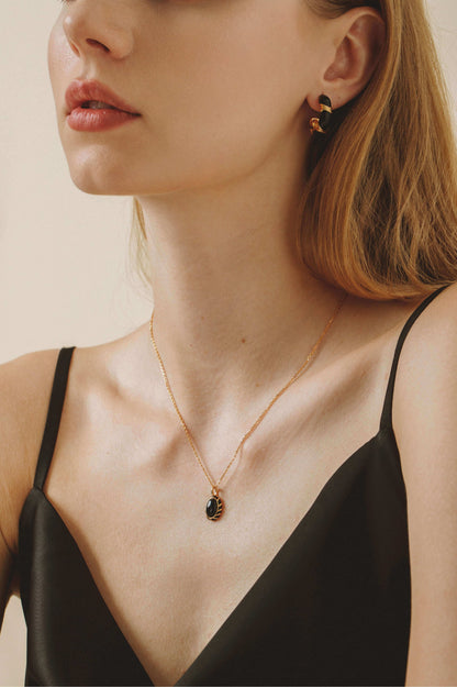 Model wearing SUIHE Jewelry Eclipse Necklace with black onyx pendant and gold chain, showcasing elegant style and dark allure.