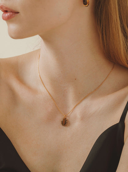 Elegant woman wearing SUIHE Jewelry "Mocha" Tiger Eye Stone Necklace with a gold vermeil chain and enamel pendant.