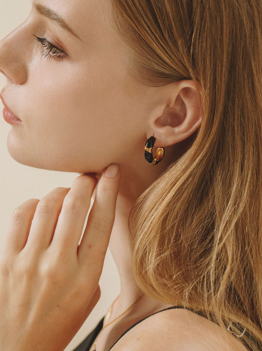 Woman wearing Eclipse black onyx and enamel hoop earrings by SUIHE Jewelry.