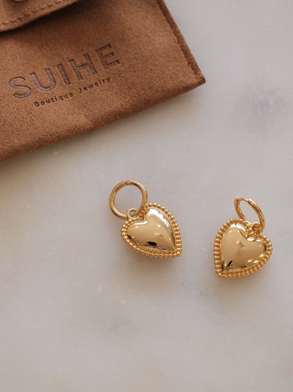 Gold heart charm hoop earrings with beaded detailing from SUIHE Jewelry, beautifully displayed on marble surface with branded pouch.