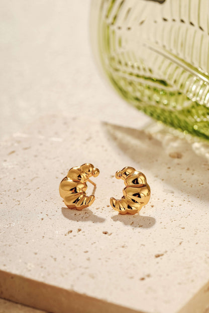 SUIHE Jewelry Croissant Stud Earrings in 18k Gold Vermeil, capturing Parisian elegance, displayed on a textured surface.