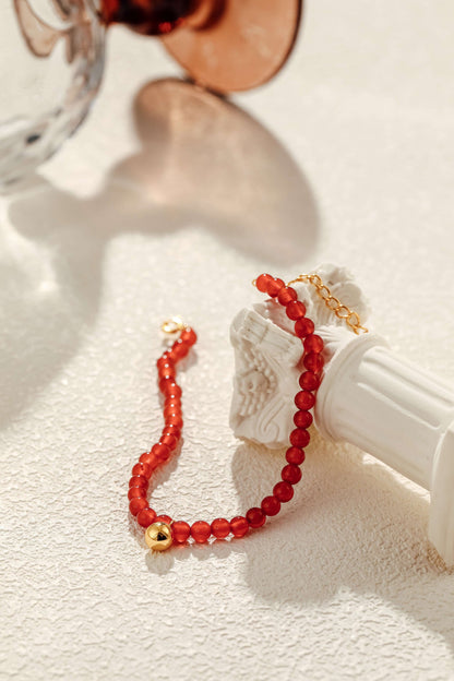 SUIHE Jewelry "Lucky" Red Agate Gemstone Bracelet with 18k Gold Vermeil, symbolizing hope and fortune, displayed elegantly on white sculpture.