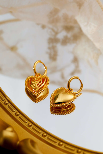 Gold-tone heart charm hoop earrings with beaded detailing by SUIHE Jewelry, elegantly displayed on a reflective surface.