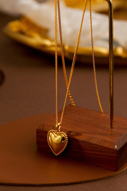 Gold-tone heart charm necklace by SUIHE Jewelry on display.