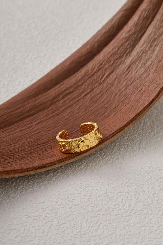 18k gold vermeil ring with croissant, pretzel and baguette charms, inspired by bread platter, on a rustic wooden surface.