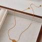 Gold-plated tennis racket necklace by SUIHE Jewelry on a display box, combining sporty chic with elegant style.