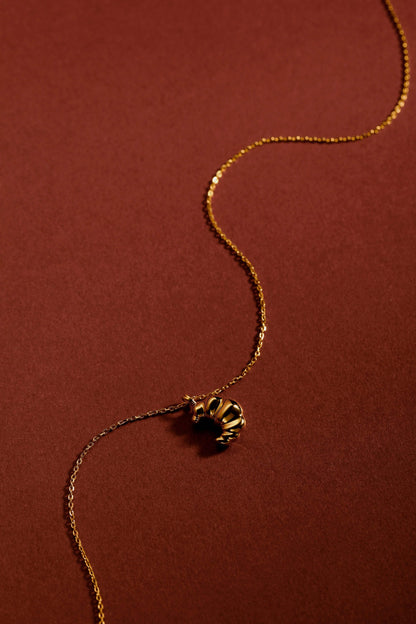 Gold "Croissant" Necklace by SUIHE Jewelry on a warm background, featuring textured charm inspired by Parisian elegance in 18k Gold Vermeil.