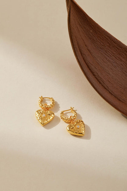 Gold-tone heart pendant earrings with starburst design and crystal center by SUIHE Jewelry