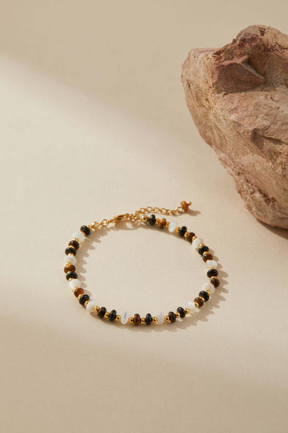 "SUIHE Jewelry Marble Bracelet with marbled beads, gold accents, and pearls on beige background showcasing elegance and versatility."