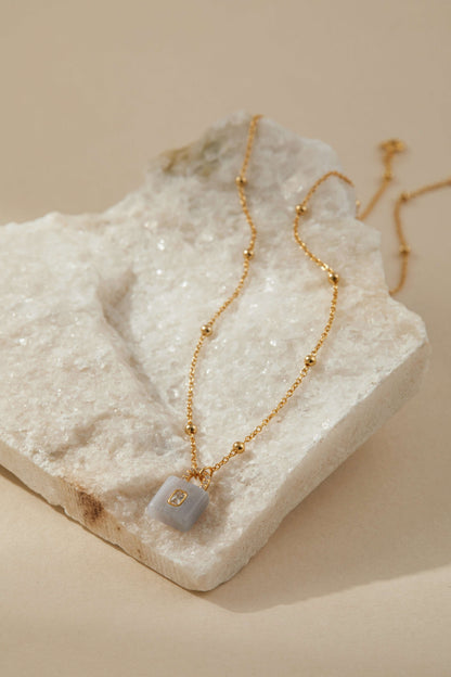 SUIHE Jewelry aquamarine stone lock necklace on gold-plated chain with zircon accent, symbolizing elegance, clarity, and tranquility.