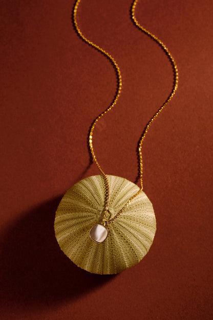 SUIHE Jewelry "Moonlight" Mother-of-Pearl Necklace in 18k Gold Vermeil, capturing subtle elegance on a warm brown background.