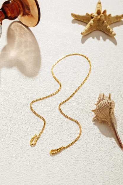 Twist Gold Chain Necklace by SUIHE Jewelry, featuring a sophisticated twisted design, styled with seashells and a starfish background.
