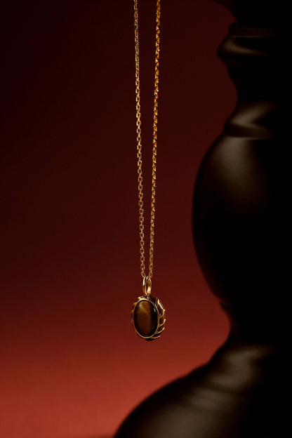 Golden SUIHE Jewelry "Mocha" necklace with tiger eye pendant on dark background, exuding warmth and sophistication.