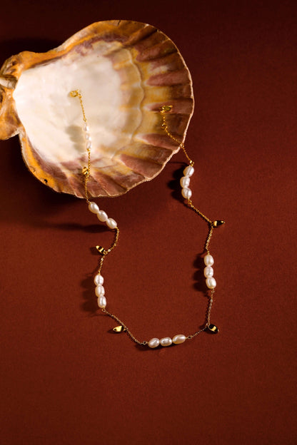 "Candybean" Pearl Necklace by SUIHE Jewelry, featuring irregular-shaped pearls on a gold-plated chain, styled with a seashell.