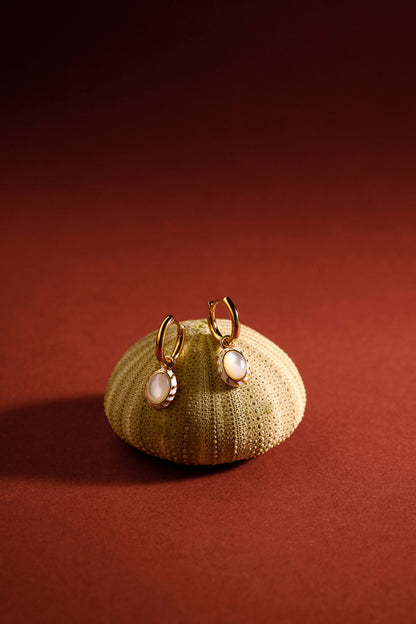 Luna mother-of-pearl pendant earrings by SUIHE Jewelry in 18k gold vermeil, featuring elegant white enamel accents on a textured background.