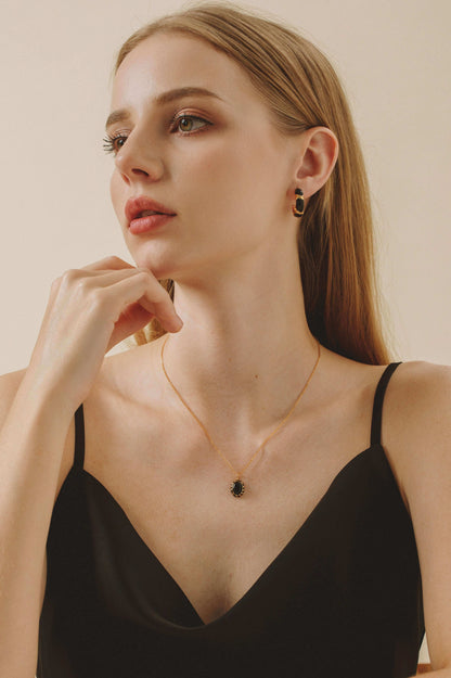 Model wearing Eclipse necklace featuring a black onyx pendant with black enamel on a gold vermeil chain by SUIHE Jewelry.