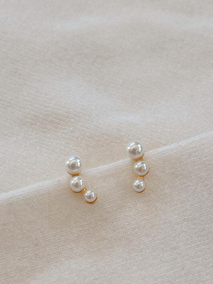 "Flare" freshwater pearl earrings by SUIHE Jewelry with 18k gold vermeil on soft fabric background.