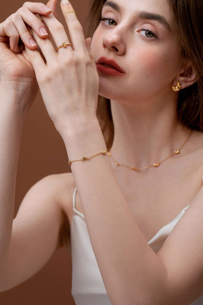 Model wearing SUIHE Jewelry Croissant Mini Charm Bracelet, gold-plated with dainty croissants, exuding French elegance.