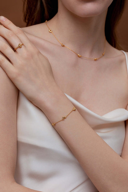 Woman wearing SUIHE Jewelry Croissant Mini Charm Bracelet, gold-plated with croissant charms, showcasing elegance and French sophistication.