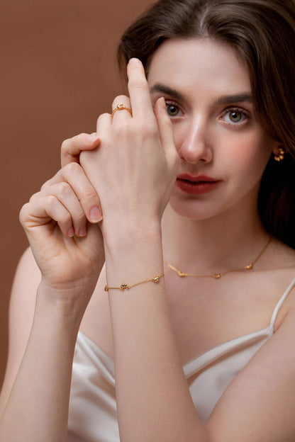Woman wearing SUIHE Jewelry Croissant Mini Charm Bracelet, featuring a dainty gold-plated chain with tiny croissant charms.