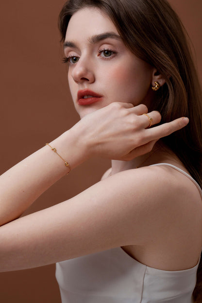 Elegant woman wearing SUIHE Jewelry Croissant Mini Charm Bracelet with delicate gold and croissant design.