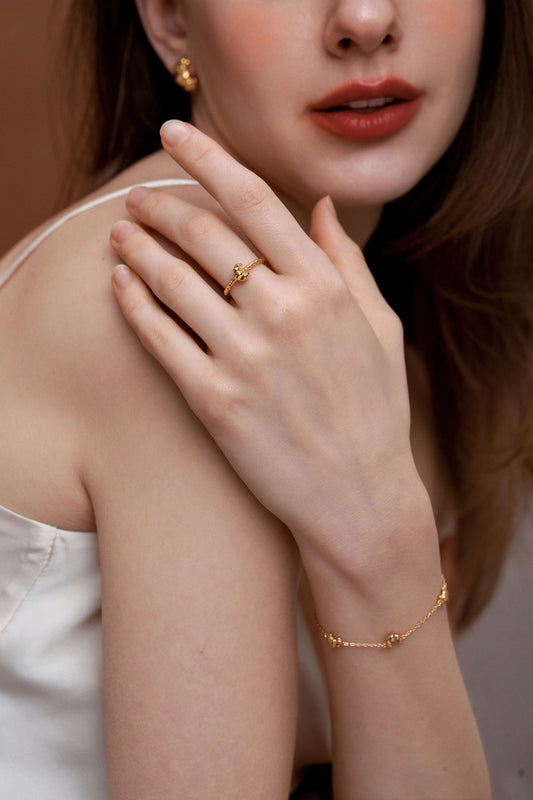 Woman wearing SUIHE Jewelry Croissant open cuff ring and gold bracelet