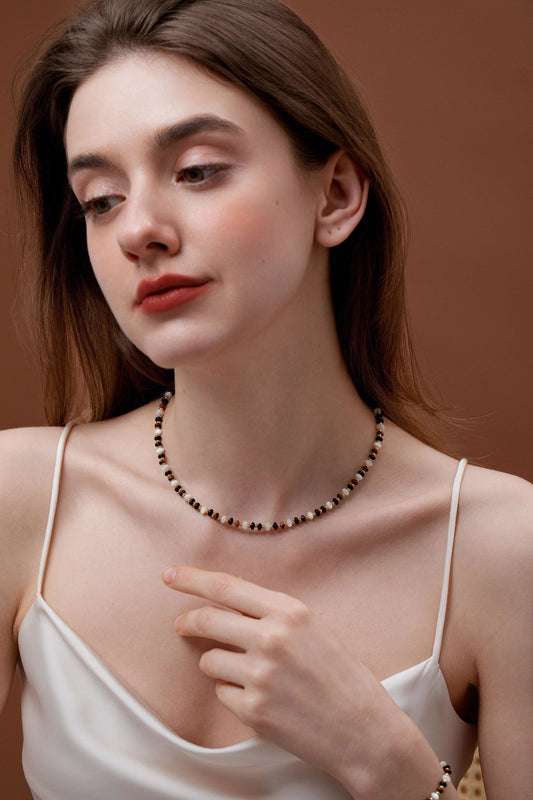 Woman wearing the Marble natural gemstone necklace by SUIHE Jewelry, featuring marbled beads, pearls, and gold-tone accents.