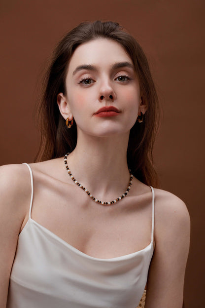 Elegant woman wearing a SUIHE Jewelry marble gemstone necklace with pearls and gold accents, showcasing timeless elegance.