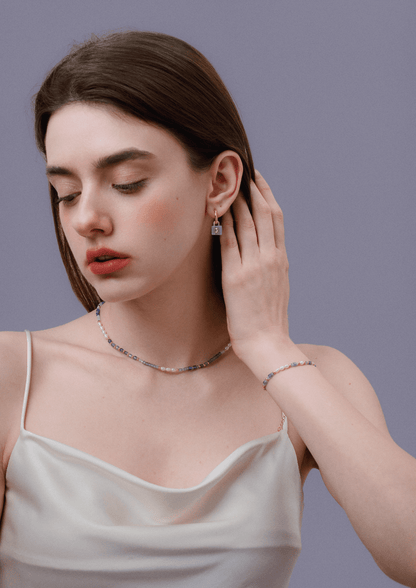 Model wearing SUIHE Jewelry's Lock Aquamarine Stone Earrings with gold-plated hoops, showcasing serene aquamarine and zicron detailing.