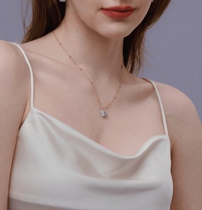 Woman wearing gold chain with aquamarine lock pendant from SUIHE Jewelry