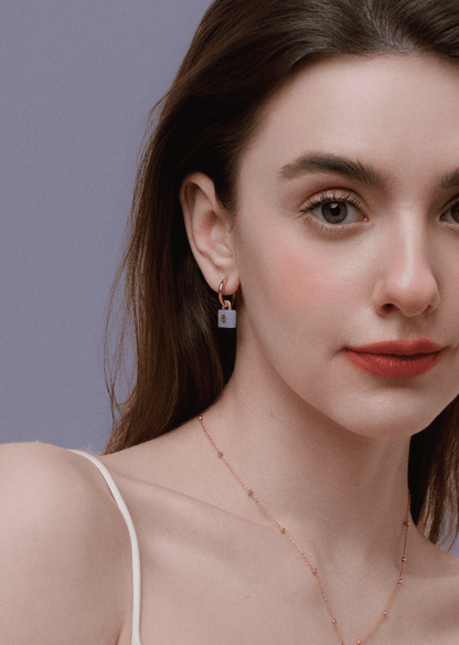 Woman wearing SUIHE Jewelry aquamarine lock earrings with gold-plated huggie hoops, showcasing elegance and serenity.
