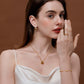 Woman wearing stylish jewelry, including a necklace, bracelet, and earrings on a brown background, showcasing an elegant fashion look.