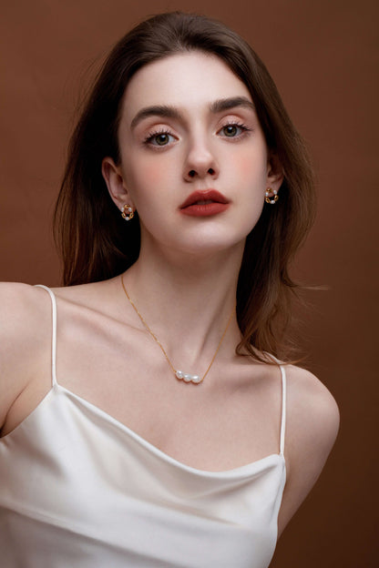 Woman wearing 'Baroque Tears' freshwater pearl necklace by SUIHE Jewelry on 18k gold vermeil chain, showcasing modern elegance.