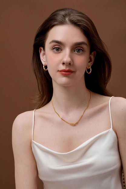 Woman wearing Twist Gold Chain Necklace by SUIHE Jewelry, featuring twisted design and artistic touch, paired with elegant earrings.