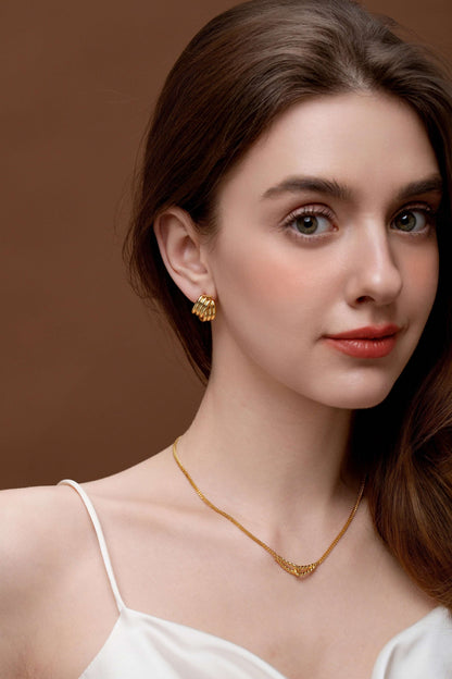 Woman wearing SUIHE Jewelry's Twist Gold Chain Necklace and matching earrings, showcasing elegant and sophisticated gold accessories.