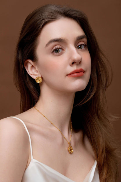Woman wears SUIHE Jewelry Pear Necklace in 18K gold with a delicate gold chain and bead accents, matching gold earrings, elegant look.