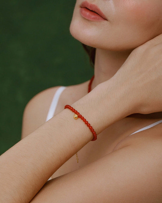 Woman wearing Lucky Red Agate Gemstone Bracelet from SUIHE Jewelry, featuring 18k Gold Vermeil, symbolizing hope and inner strength.