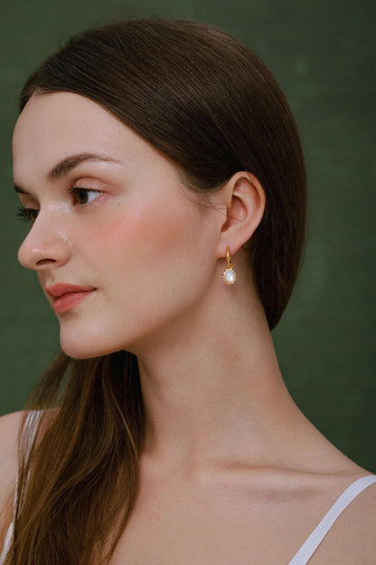 Woman wearing "Luna" Mother-of-pearl Pendant Earrings by SUIHE Jewelry, featuring 18k gold vermeil and white enamel elegance.
